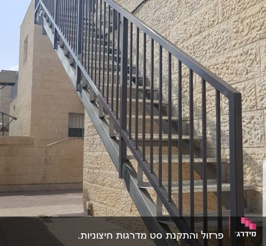 מעקה מתכת שחור לאורך מדרגות חיצוניות